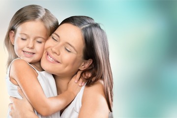 Fototapeta na wymiar Portrait of young woman with little girl on background