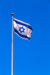 Flag of Israel waving against the blue sky