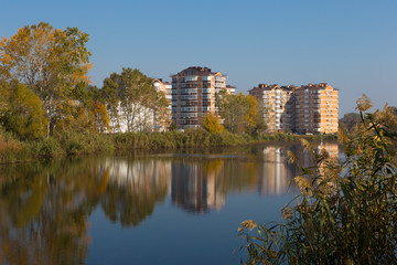 Modern residential complex on the shores of a picturesque lake on a sunny day.