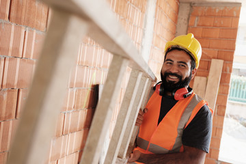 Portrait Of Happy Hispanic Worker Smiling In Construction Site - Powered by Adobe