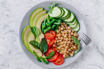 Healthy vegetarian food chickpeas, avocado, tomatoes, cucumbers, green beans top view