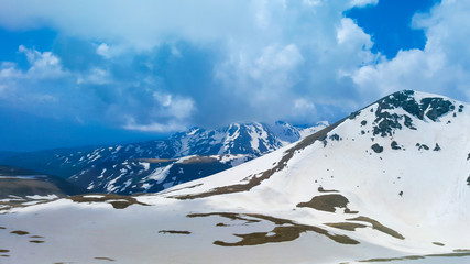 Majestic Mountain Peaks covered with Snow and soaring blue skies