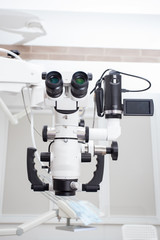 Image of a professional dental endodontic binocular microscope with a camera in the treatment room 