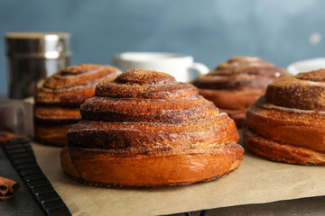 Cooling rack with freshly baked cinnamon rolls on table, closeup