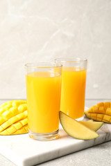 Fresh mango drink and cut fruits on table. Space for text