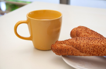 Cup of milk and bread with sesame