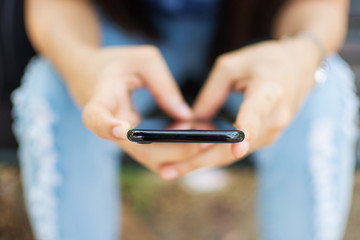 woman's hand holding smart phone with blur background. selective focus and soft focus.