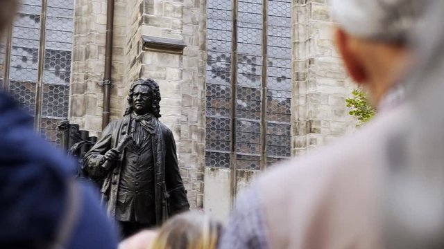 Back view crop people near sculpture of Johann Sebastian Bach on square in Leipzig 