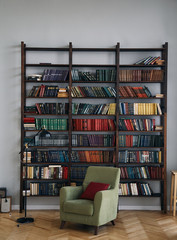 green chair in the interior. Bookcase with old books on the shelves. Books in an old wooden Cabinet