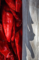 Bright red chile ristra with shadow cast on old wood
