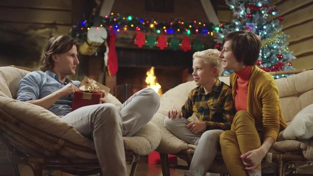 Young handsome mand looks inside his Christmas gift