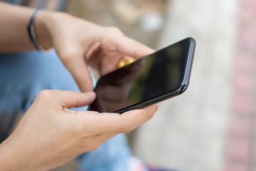 woman's hand holding smart phone with blur background. selective focus and soft focus.