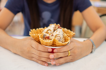 woman's hand holding ice cream cup. soft focus.