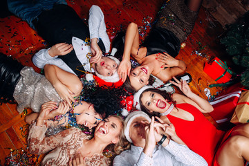 Group of friends at club having fun and lying on the floor .New year's party