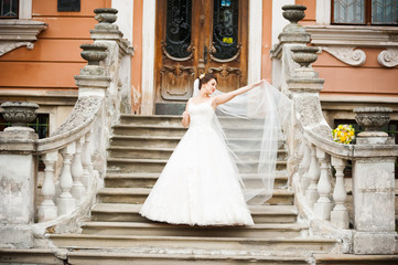 Fototapeta premium Beautiful european bride walking near old castle and have fun