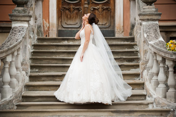 Fototapeta premium Beautiful european bride walking near old castle and have fun