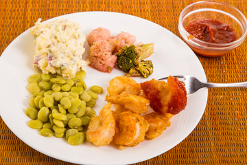 Deep Fried Tempura Battered Shrimp dipped in cocktail sauce with beans and potato salad