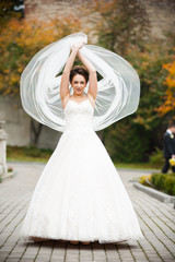 Fototapeta premium Beautiful european bride walking near old castle and have fun