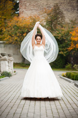 Beautiful european bride walking near old castle and have fun