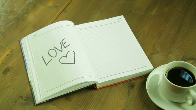 The girl writes the word love in the diary. Time laps