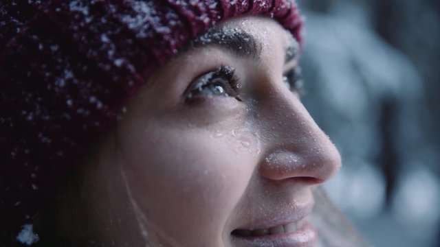 Face young woman with beautiful eyes snow falls smiling in winter park cold girl happy nature white holiday outdoor pretty attractive fashion fun happiness model portrait slow motion