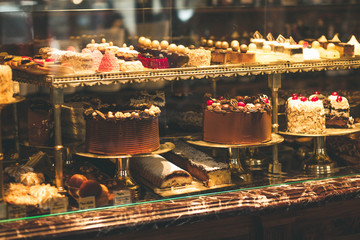 Pastry shop display window with variety of cakes