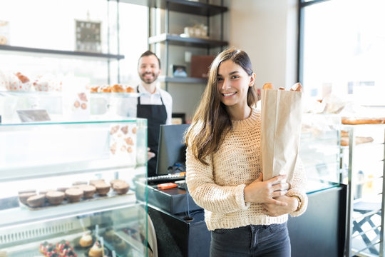 Customer With Package Of Fresh Baguettes In Bakery