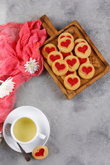 Flat lay. Cup with green tea and cookies with a heart on a decorative board. Valentine's day concept.