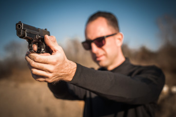 Police agent bodyguard gun pointing pistol to attacker. Front view