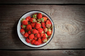 Fresh strawberries on old wooden background. Top view.