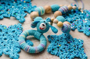 Necklace made from knitted dog and toys for the baby sitting in a sling.