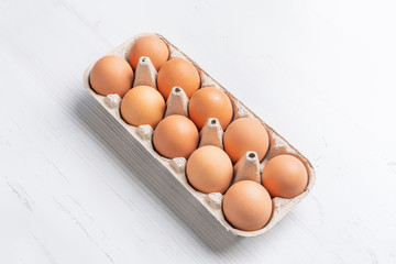 fresh eggs in paper tray on white surface b