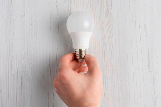 Lightbulb Lying On White Background And Hand Holding It B