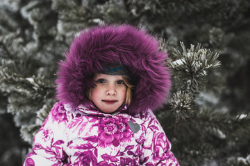 beautiful little girl in the snowy woods