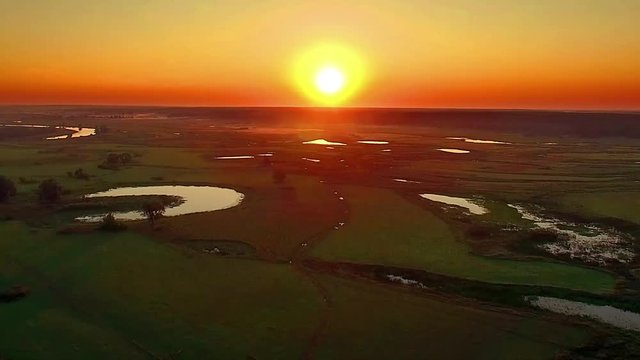 aerial view of river at sunrise, forest and river in morning mist,  Flying over the river green trees at sunrise, Very high view of the river forest at sunrise