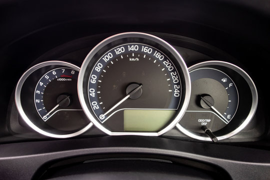 A detail of a dashboard of a modern car with odometer and other instruments