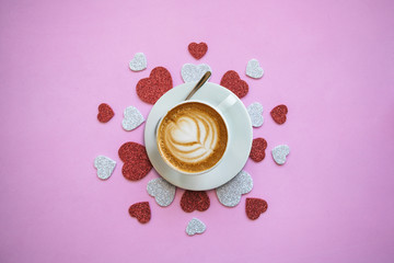 Fragrant delicious cappuccino on a festive background with many hearts. Concept for Valentine's Day or Women's Day.