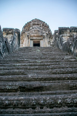 Fototapeta premium iew up the steep stairs at Angkor wat. Originally constructed in the early 12th century, the ruins are a huge tourist attraction as well as a place of worship today