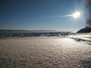 Winter sunny beach overlooking the foggy mountains 