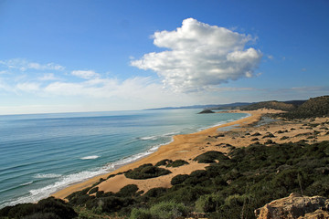 Goldstrand der Halbinsel Karpaz auf Zypern, eingebettet in eine mediterranen Landschaft und blauen Sommerhimmel mit weißen Wolken