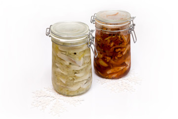 Wigilijne śledzie w słoikach na białym tle