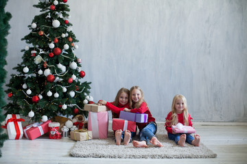 three girls opens Christmas presents new year Christmas tree Garland