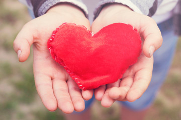 Fototapeta premium Bright symbol of love in children palms