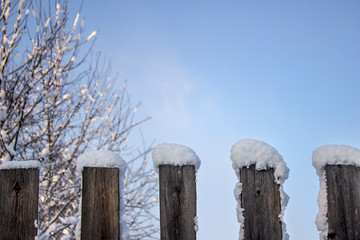 Snow-covered old fence close-up