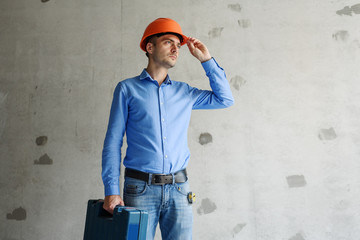 Construction worker with tools in new house. Renovation background.