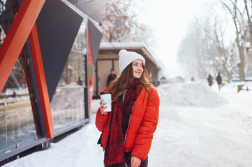 Fototapeta na wymiar Portrait happy and beautiful girl in winter street heated coffee and smile.