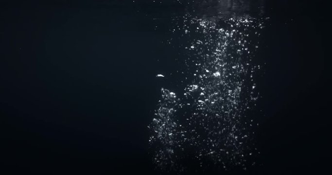 4K underwater illuminated bubbles in slow motion. Ocean floor bubbles. Marine background VFX element.