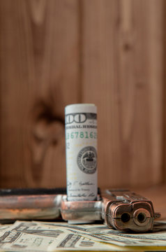 Stack of Money, drugsand a gun on a wooden table, concept about danger and threat of the drug