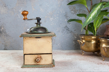 Old coffee grinder on concrete background.