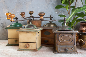 Old coffee grinders on concrete background.